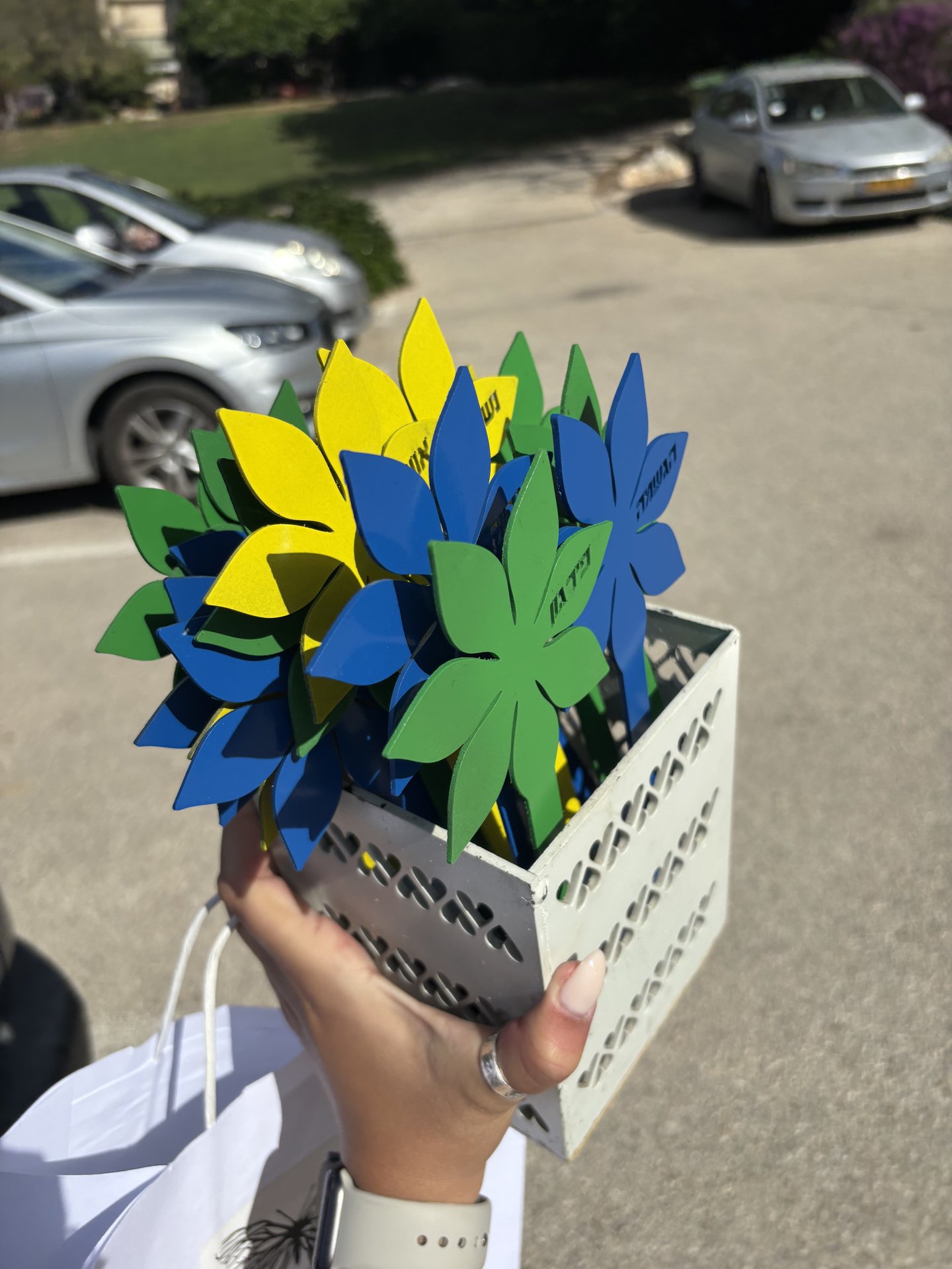 פרחי מתכת צבועים בכחול, צהוב וירוק בסלסלה