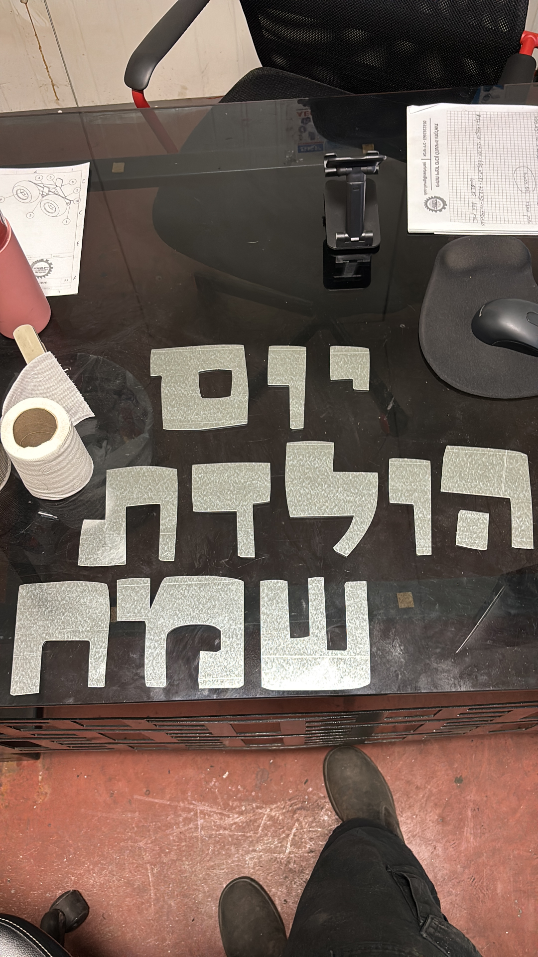אותיות מתכת חתוכות בכיתוב „יום הולדת שמח” על שולחן בסדנה
